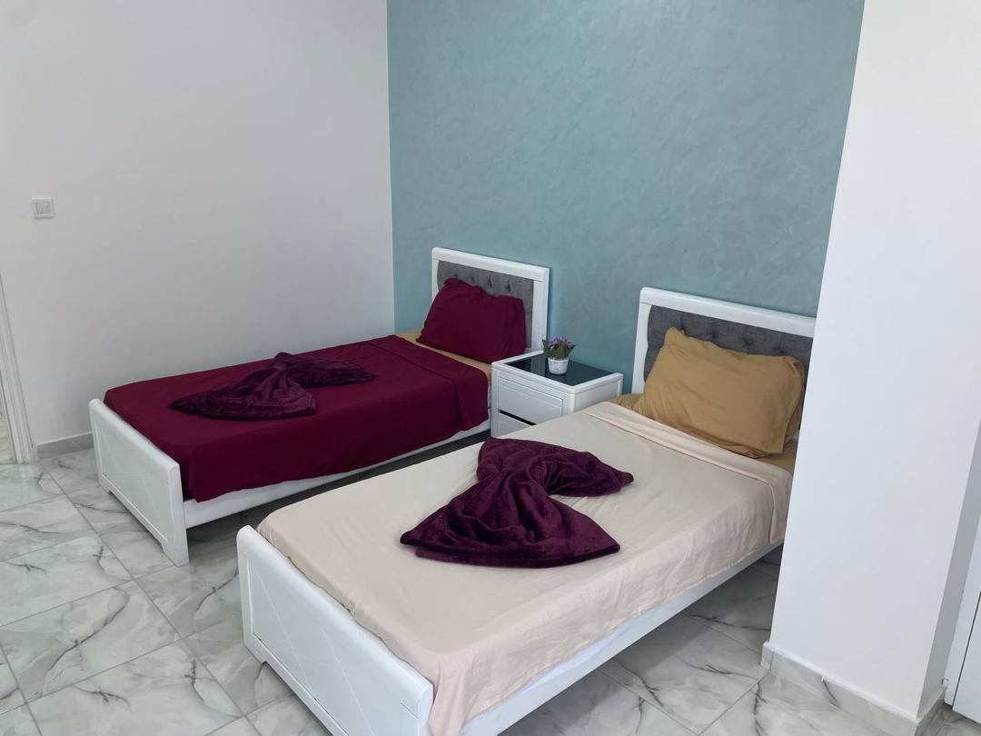 Chambre lits simples mur bleu bordeaux